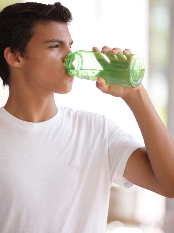 A teen drinking from a water bottle.
