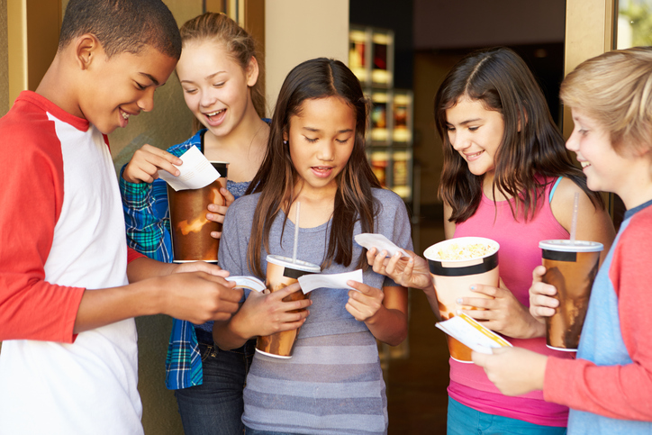 A group of young people holding movie tickets.