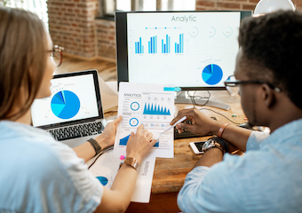 Two people analyzing graphs.