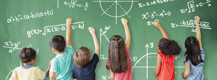 Children writing on a chalk board.