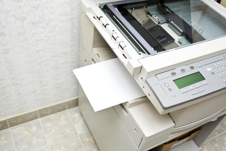 A photo of a photocopier creating copies.